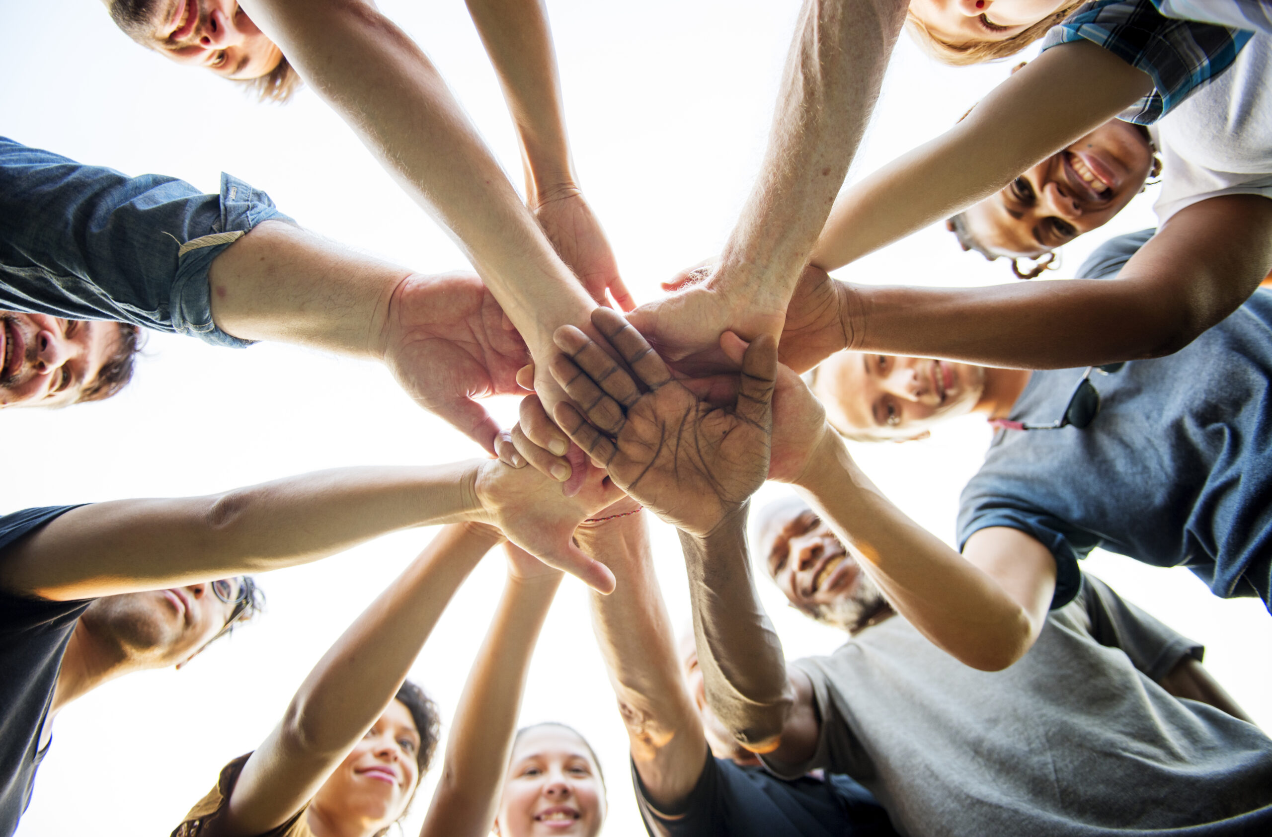 Group of people Holding Hands Assemble Togetherness From Underneath Group of people Holding Hands Assemble Togetherness From Underneath